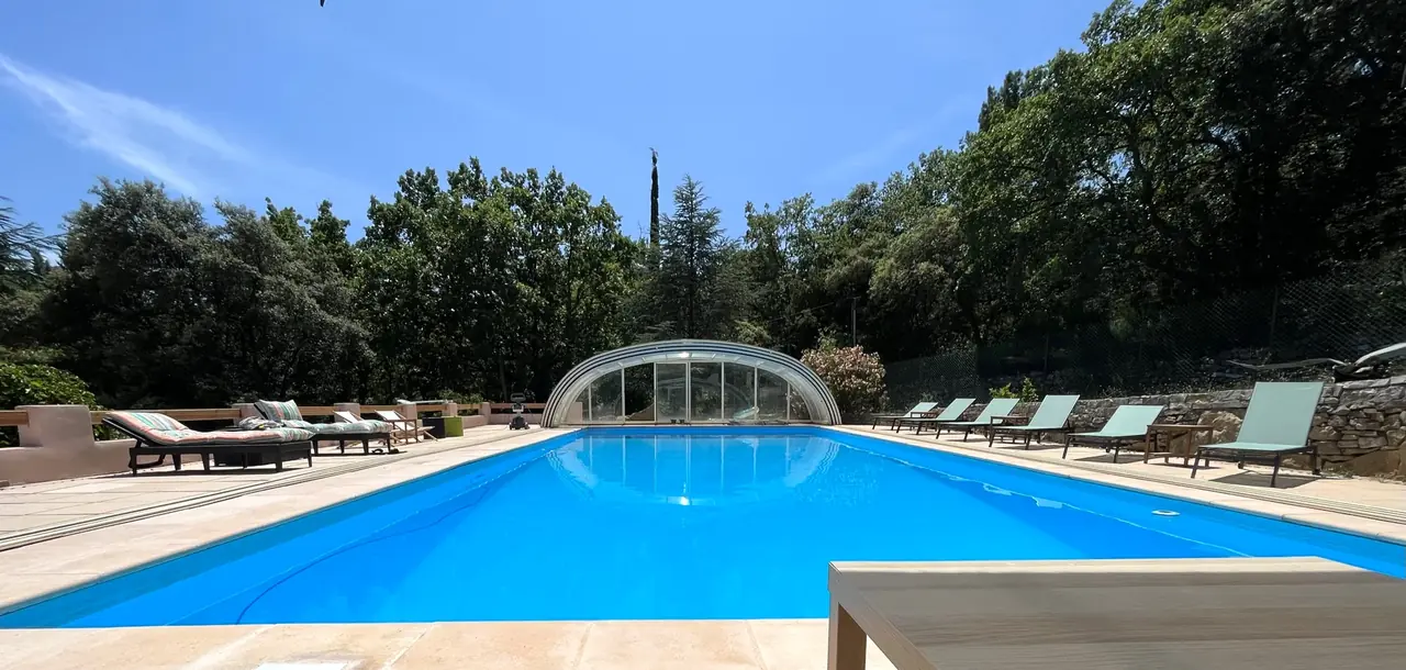 La grande piscine du Domaine de l'Issole et ses transats, dôme ouvert