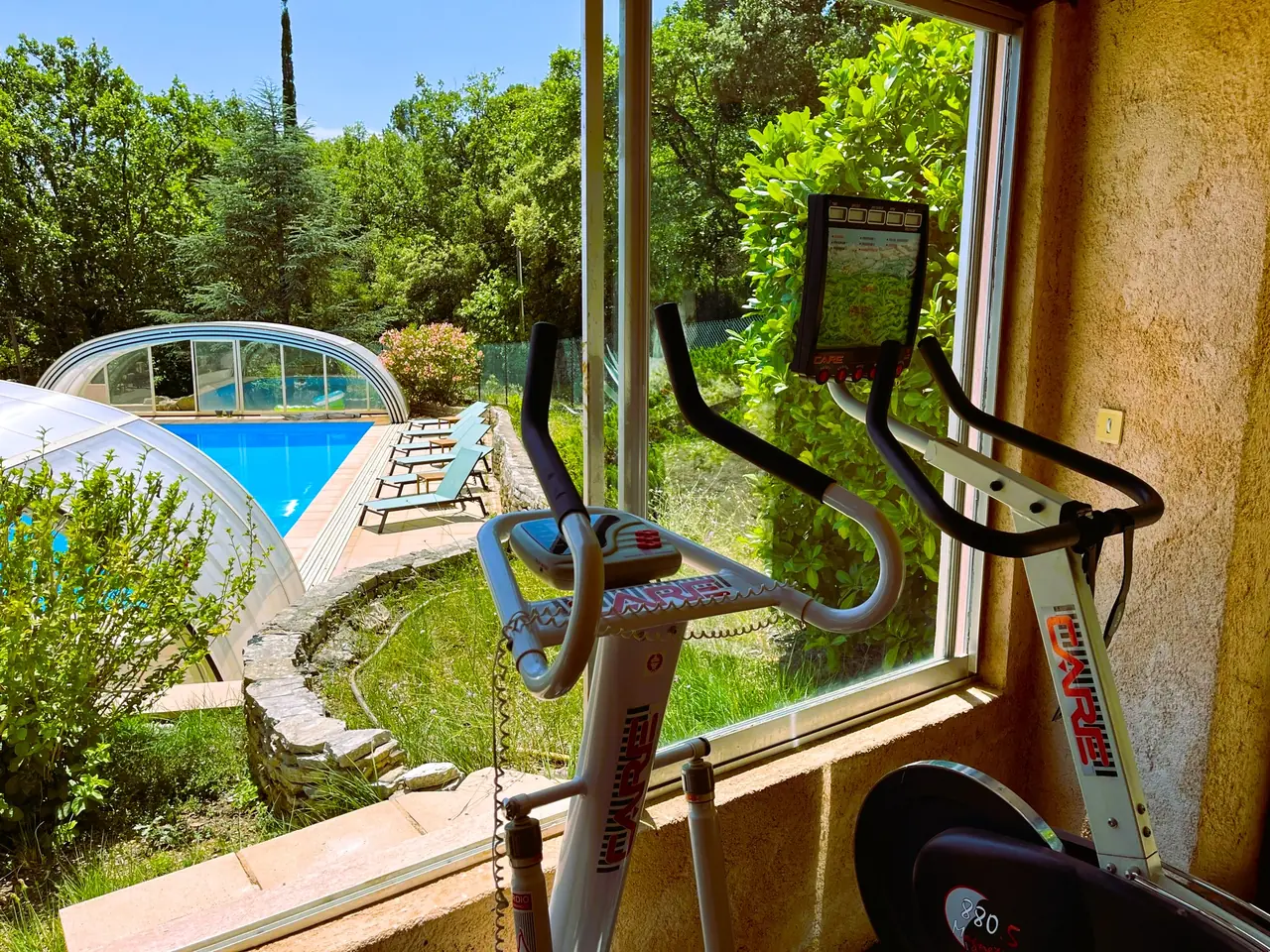 La salle de sport avec vue sur la piscine