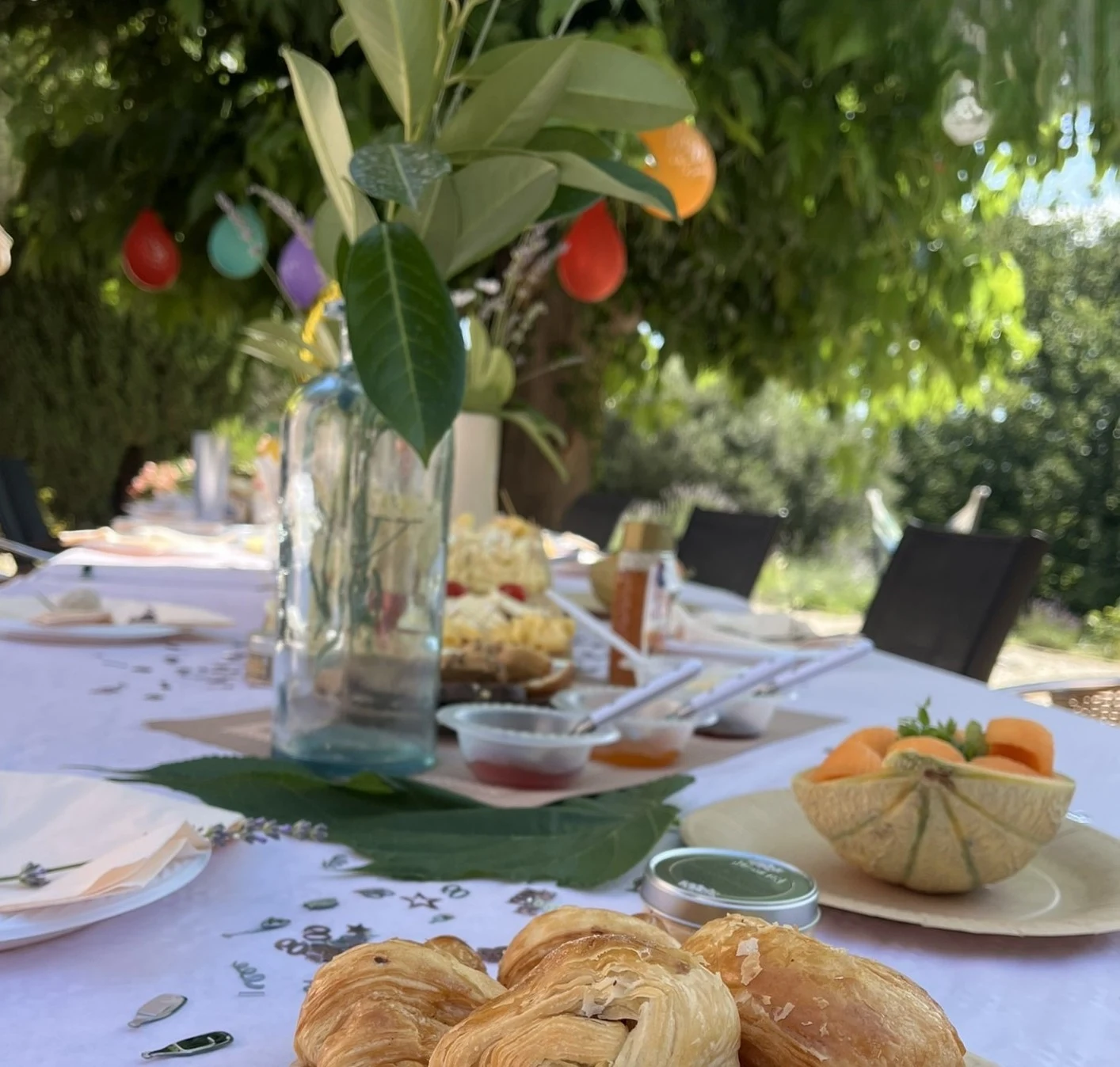 Long table laid under the trees for a private reception