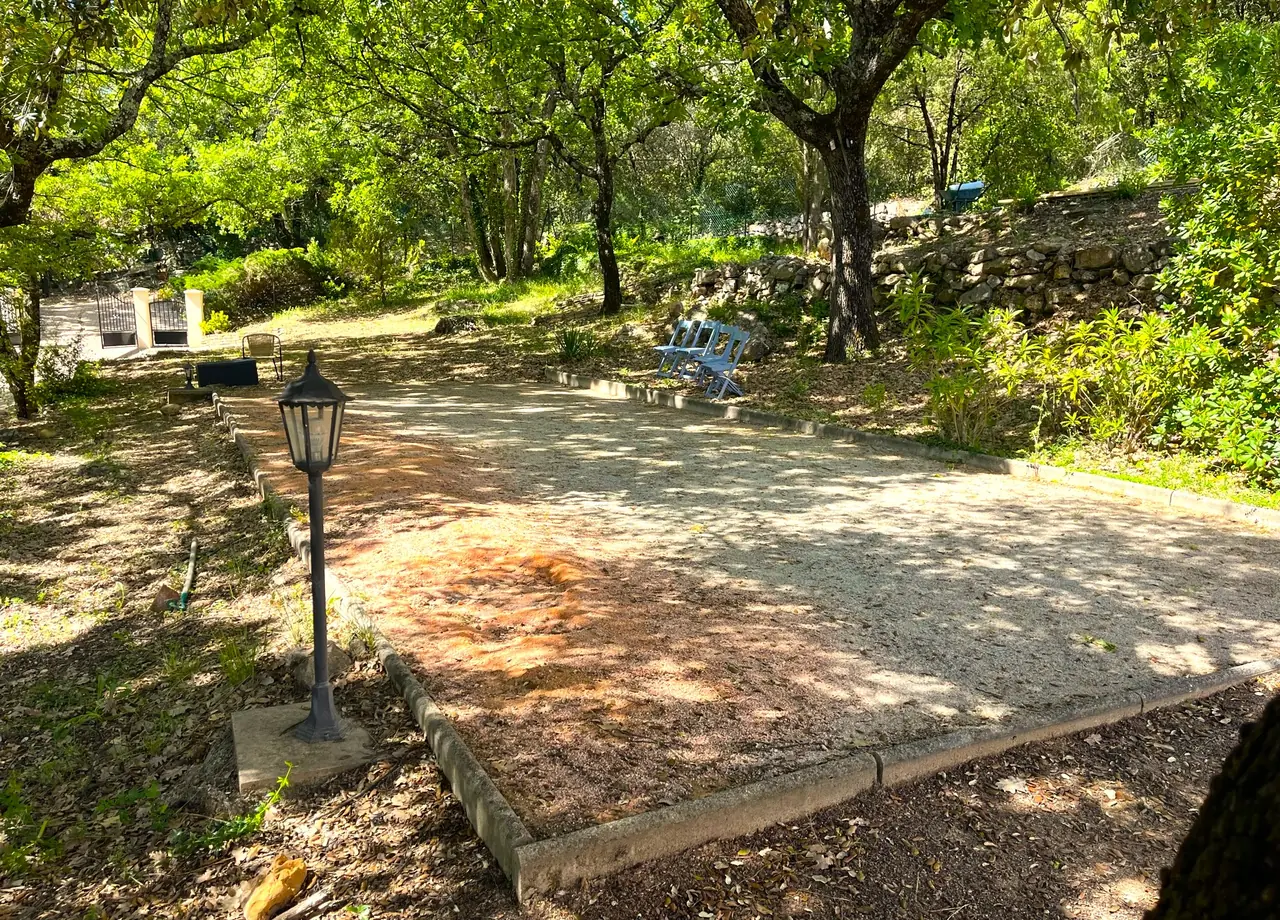 Le terrain de pétanque sous les chênes