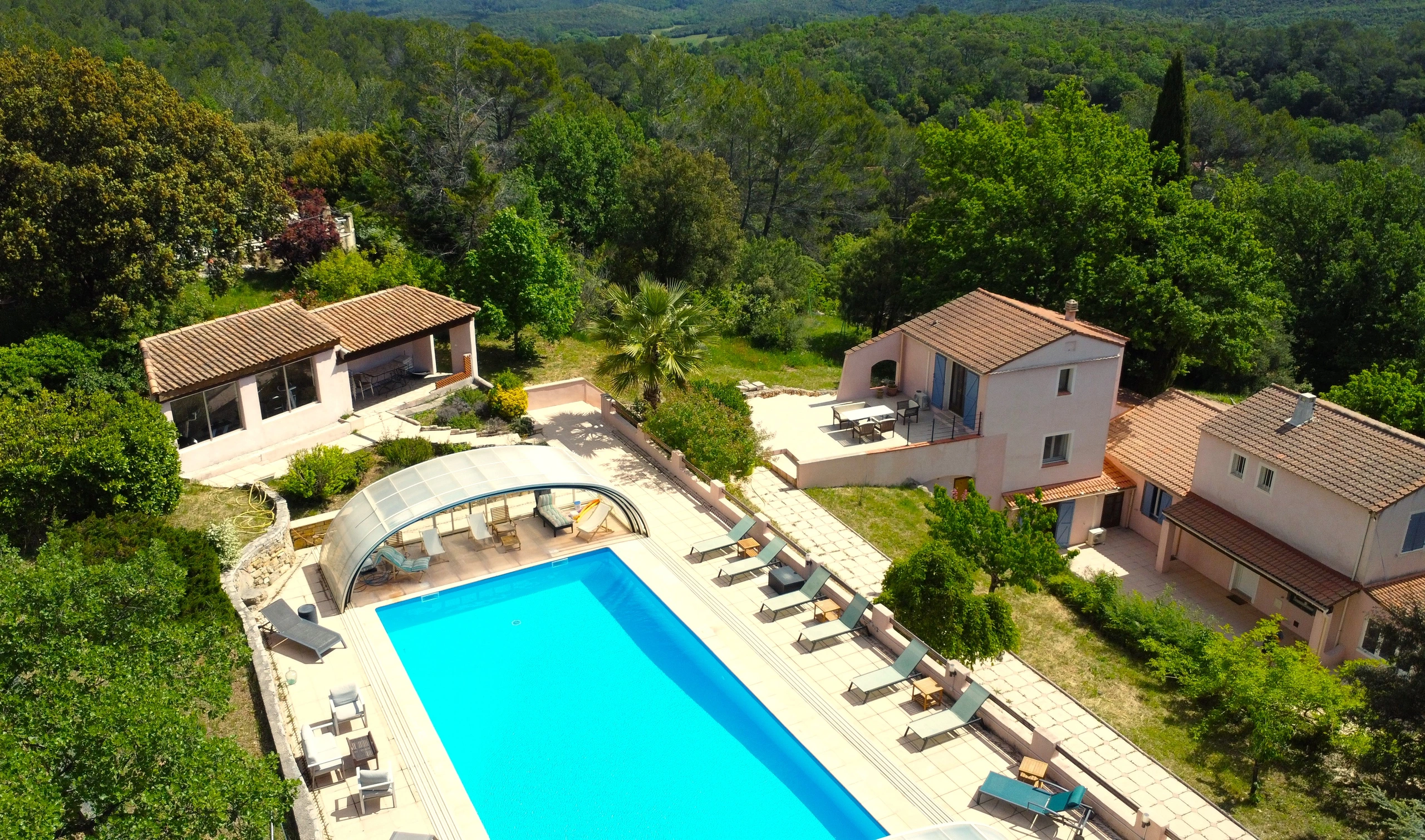 Vue aérienne du Domaine de l'Issole : la piscine et ses transats, la maison et le parc dans le Var
